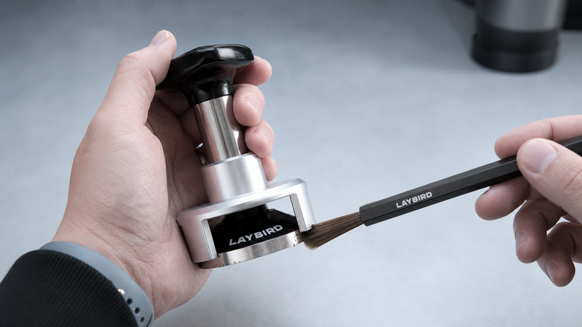 Cleaning the LAYBIRD TriPress pressure tamper with the included coffee brush